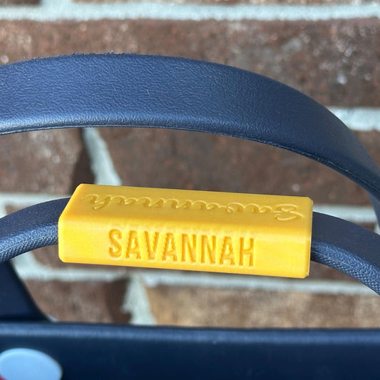 a 3d printed personalizedplasticname plateon a boggbag handle