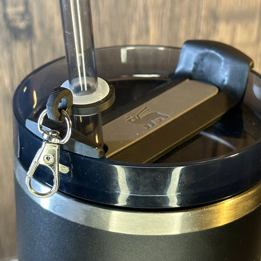 a metal clasp is attached to a tumbler straw using a plastic ring and grommet